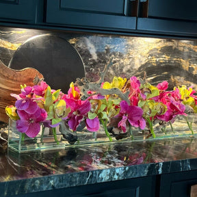 Jarrón de cristal de estilo moderno con orquídeas Vanda rosas y cymbidiums verdes.