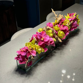 Jarrón de cristal de estilo moderno con orquídeas Vanda rosas y cymbidiums verdes.
