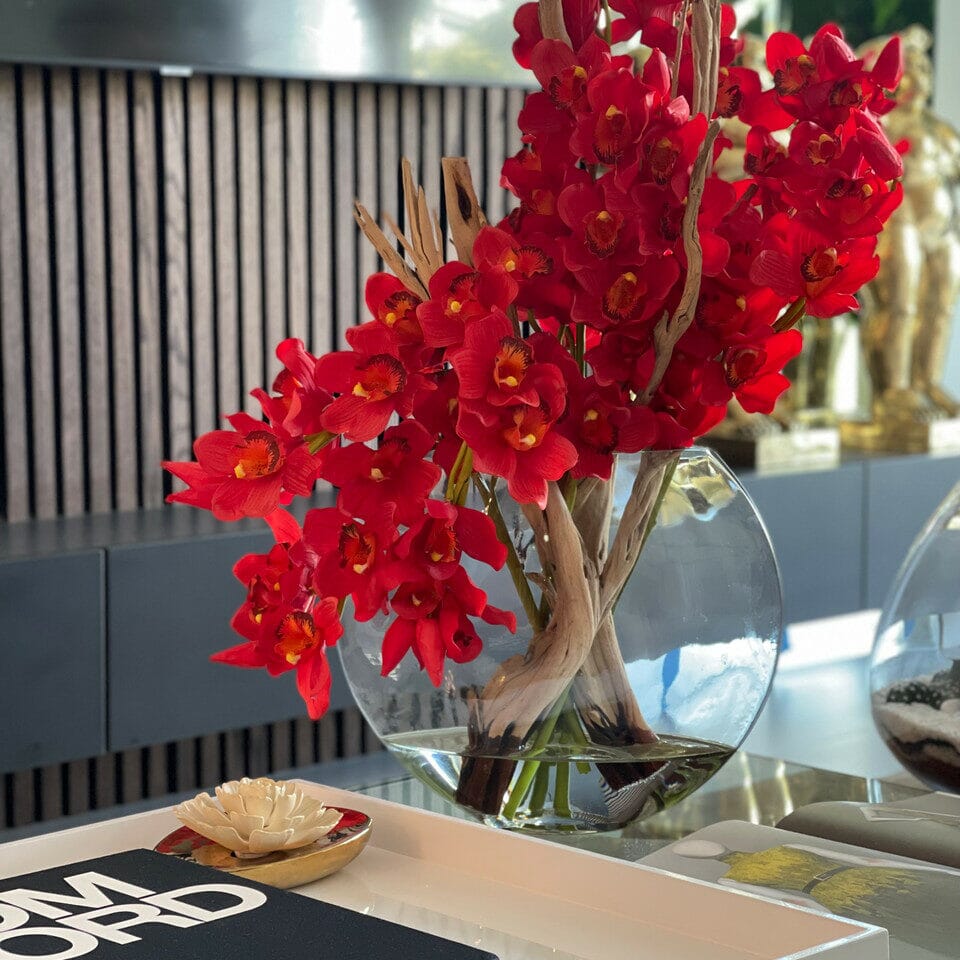 Cymbidiums rojos en jarrón Moon
